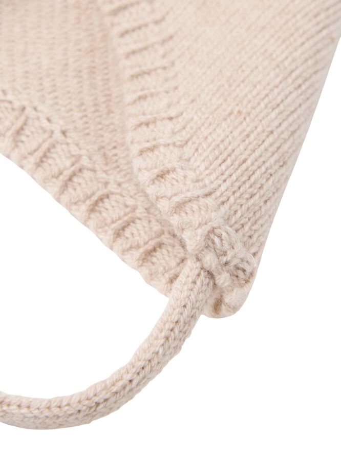 Stickad mössa i mjuk ull med knytb